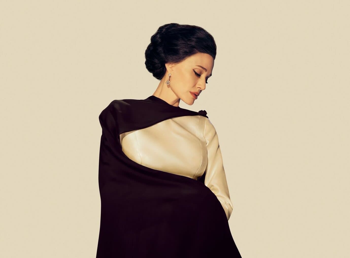 Elegant portrait of Angelina Jolie as Maria Callas in a cream top and dark cape.
